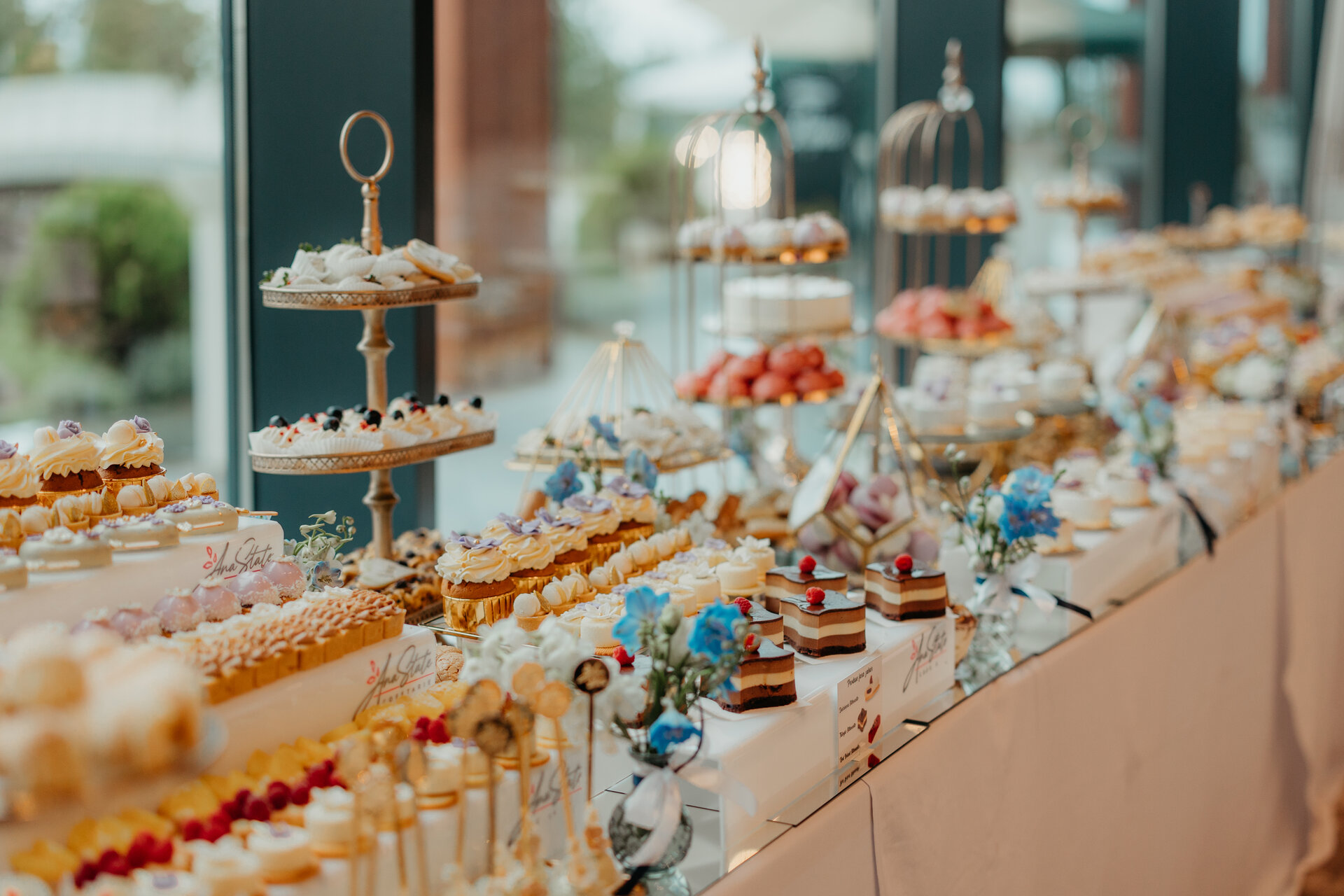 Candy bar nuntă cu standuri aurii și deserturi fine Ana State